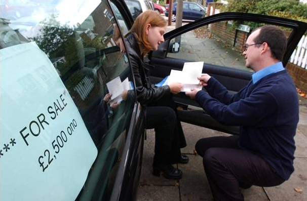 Second-hand car buyer checking paperwork
