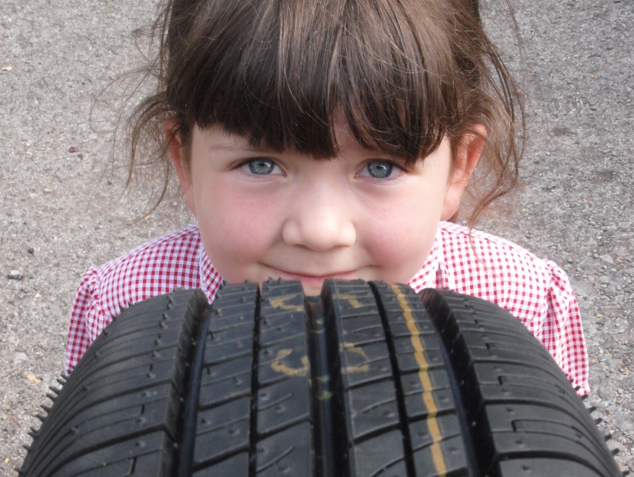 Child inspecting tyre
