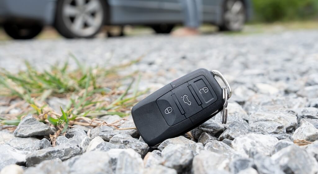 A car key fob is on the ground.