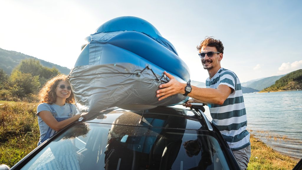 A kayak on the top of a car.