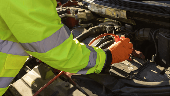 A roadside technician checks a failing car battery.