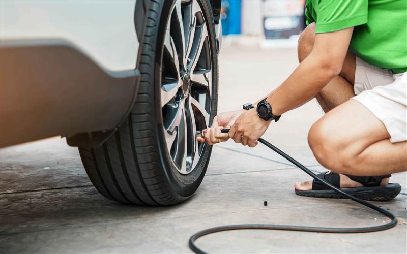 person in green shirt checking tyre pressure