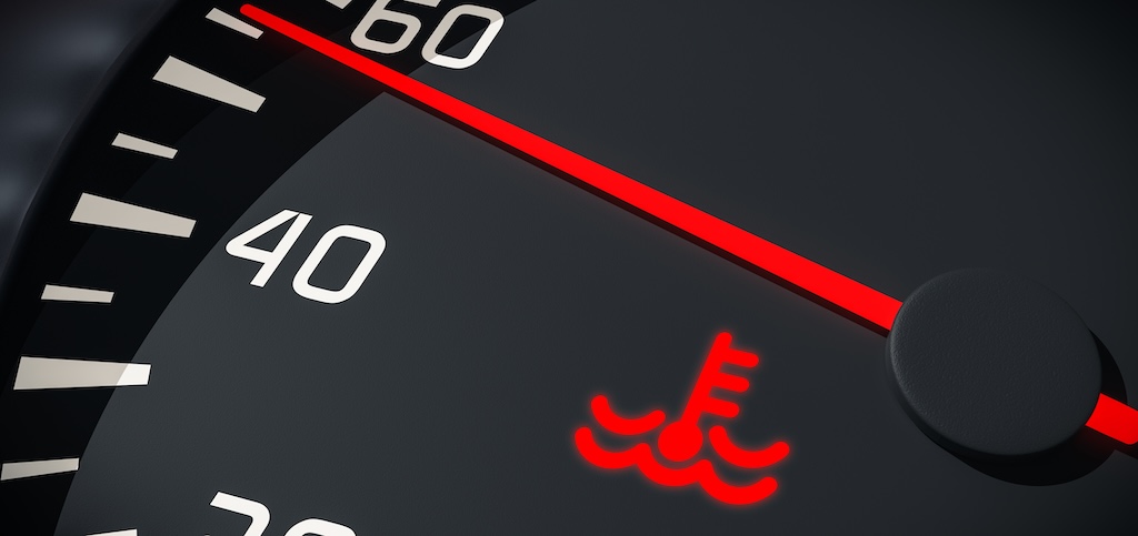 A car dashboard temperature gauge indicates the car's engine is overheating.